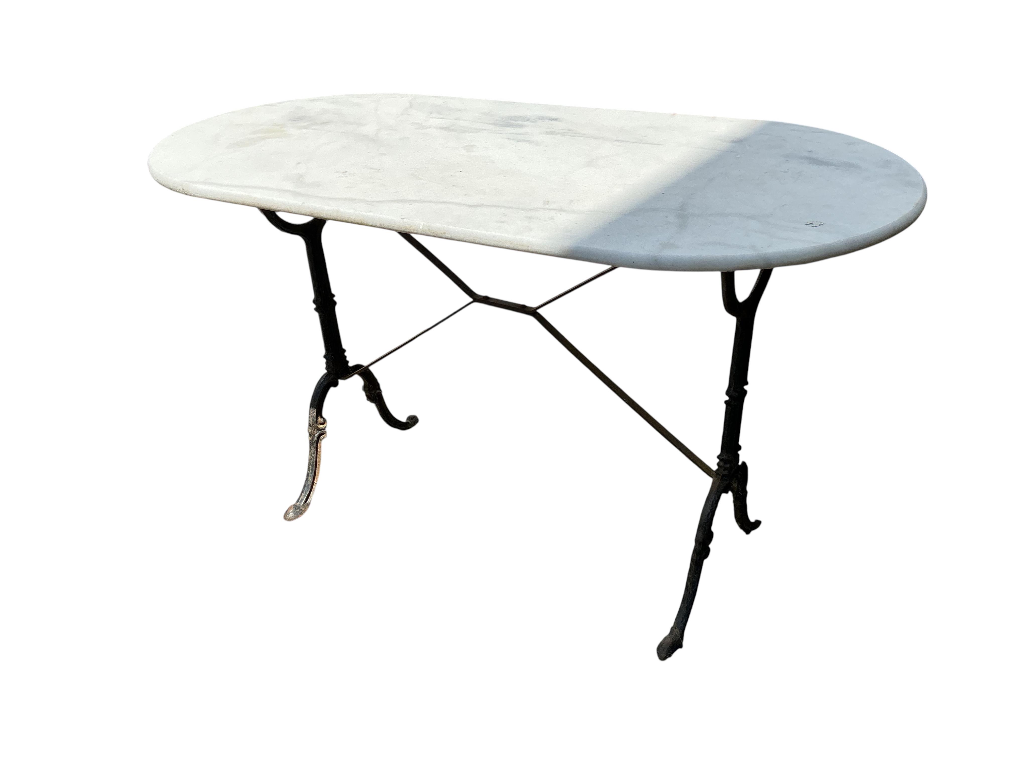 An oval reconstituted marble and cast iron garden table, width 120cm, depth 60cm, height 71cm